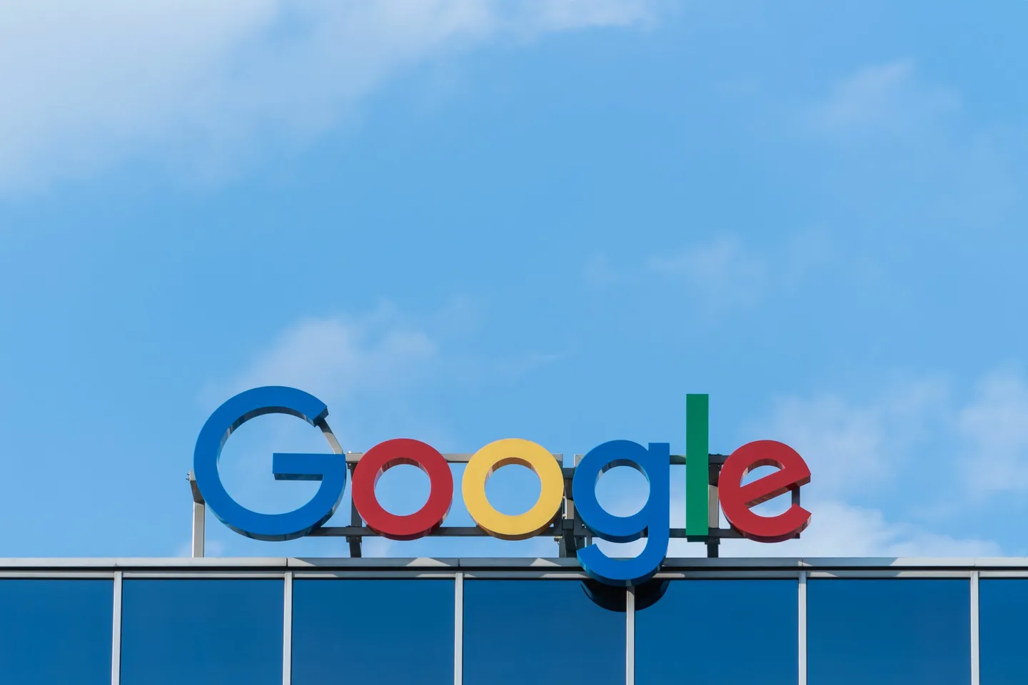 Google-skilt på en bygning mot blå himmel.